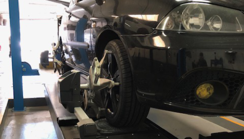 Mechanic checking a vehicles wheels - Wheel Alignment Heanor